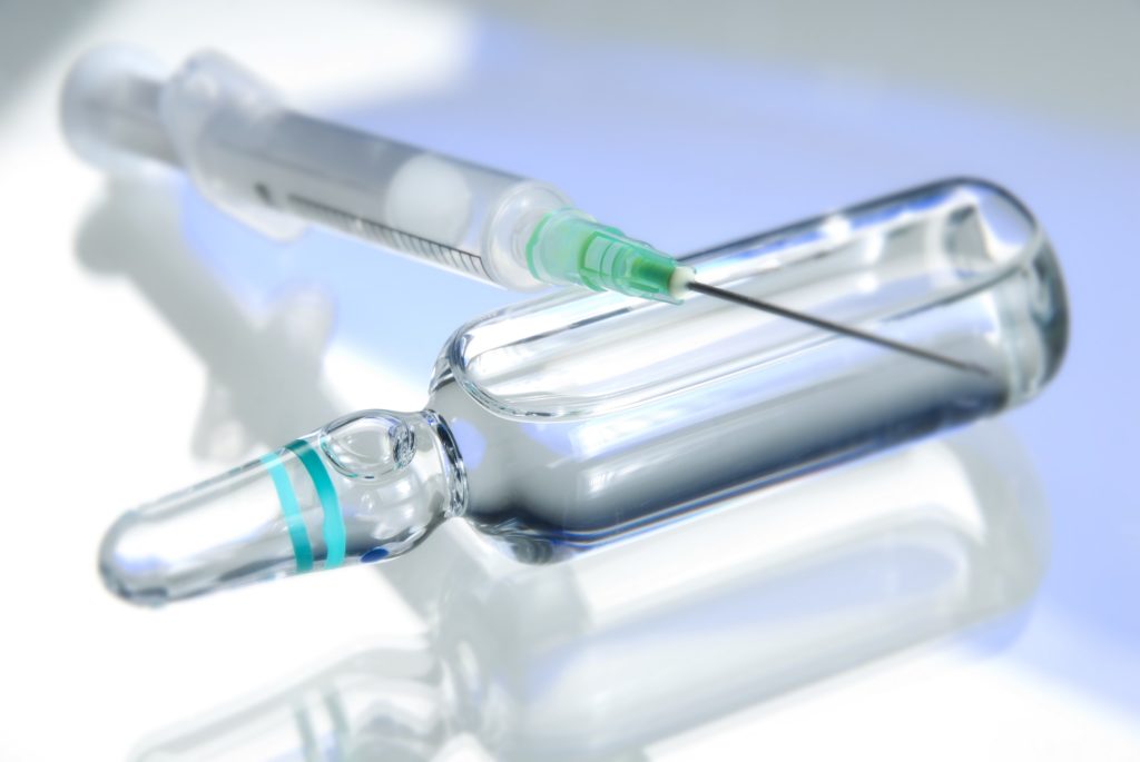 Botox solution in bottle with syringe on top representing botox treatment for capital dental patients
