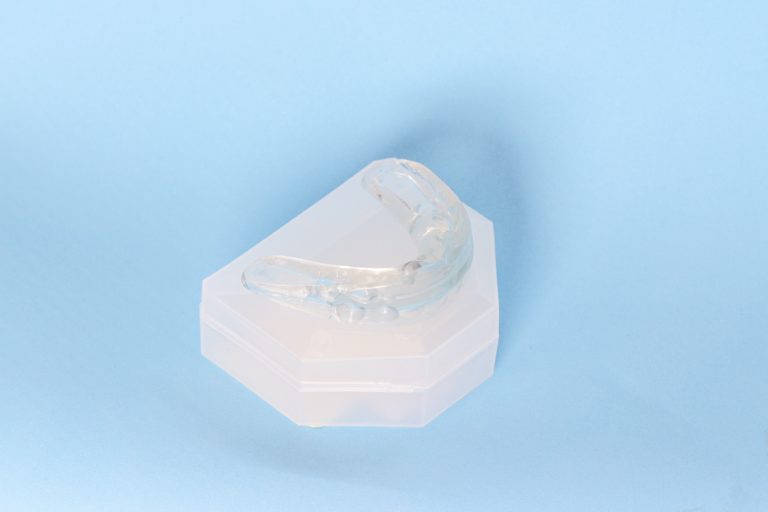 White Mouth guard on blue background to represent custom mouth guards at capital dental in lincoln nebraska