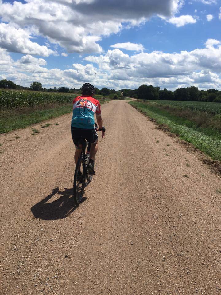 Dr. Killeen riding his bike on a gravel road