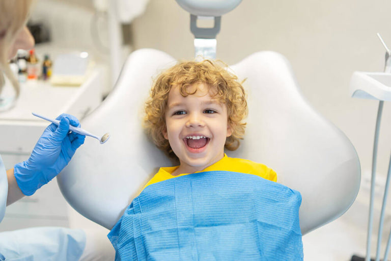 A young boy sits in a dental exam chair during a checkup